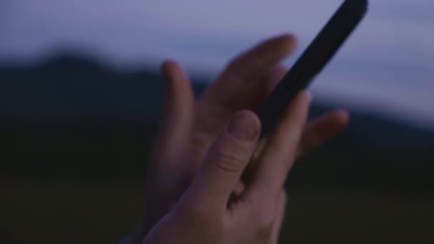 Tanımlanamayan Bir Kadının Gece Vakti Arka Plandaki Dağlarda Akıllı Telefondan — Stok video
