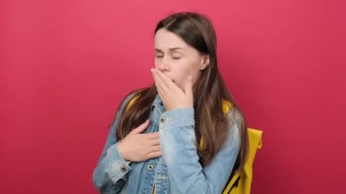 Portrait of scared young brunette woman 20s old years with yellow backpack gaping because have just surprised with gift, posing isolated over red color background wall in studio. Education concept