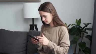 Euphoric happy young female 20s looking at smartphone screen, getting message or email with unbelievable good news, getting big sale discount for internet shopping or celebrating online lottery win