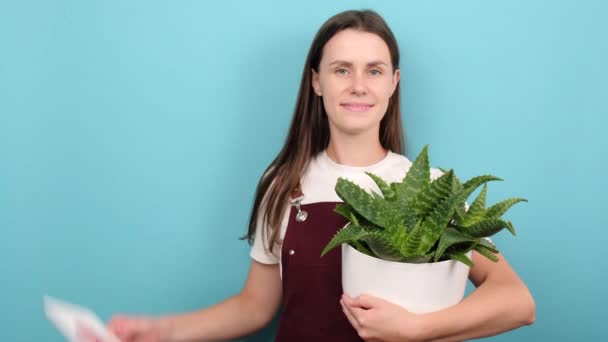 Smiling Young Woman Florist Holding Heart Icon Plants Pot Recommending — Stok Video