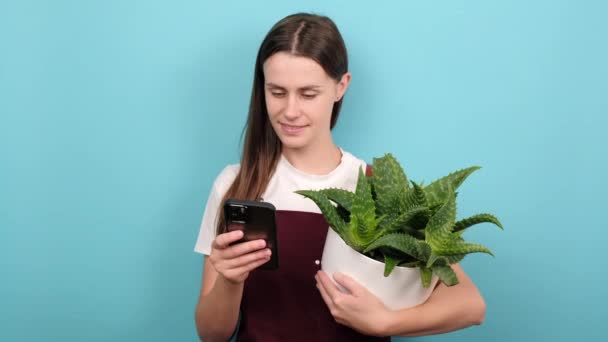 Happy Cute Gardener Woman Holding Green Plant White Flowerpot Smartphone — Vídeo de stock