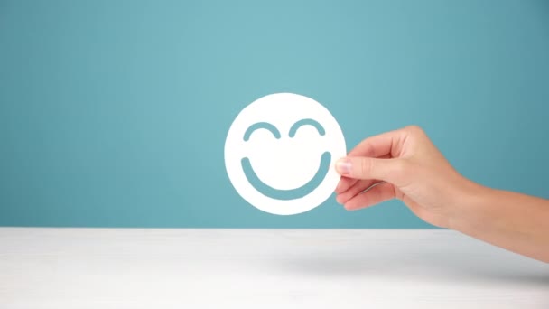 Close Mão Feminina Segurando Papel Branco Sorrindo Emoticon Mesa Posando — Vídeo de Stock