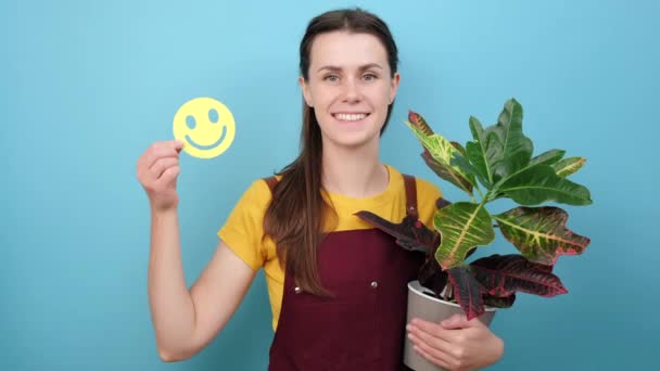 Szczęśliwa Młoda Brunetka Ogrodnik Trzyma Małe Śmieszne Emotikony Twarzy Roślin — Wideo stockowe