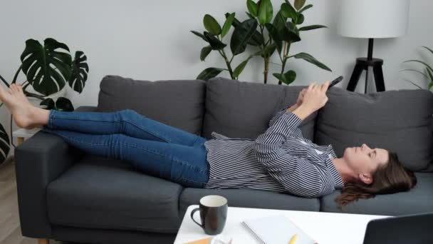 Wanita Muda Yang Kecewa Berbaring Sofa Browse Aplikasi Obrolan Telepon — Stok Video