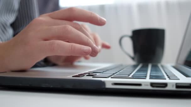在使用笔记本电脑键盘打字的女性手工操作人员的密切合作下 女孩喝咖啡坐在家里的写字台上 用Pc软件应用技术进行在线工作 创业和商业概念 — 图库视频影像