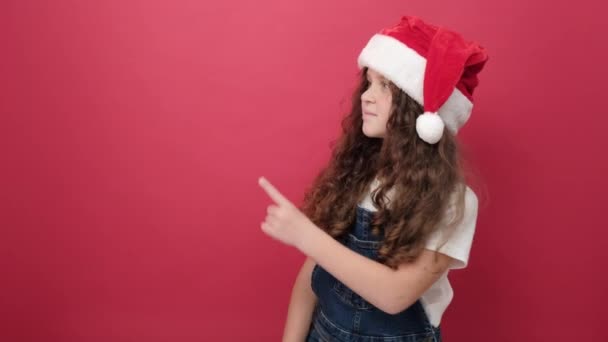 모자를 소녀가 배경에 고립된 복사본 공간을 가리키며 크리스마스 아이들을 아이들을 — 비디오