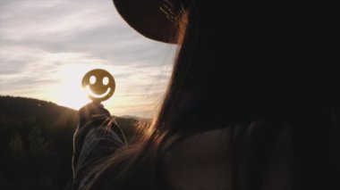Şapkalı genç bayanın gülen yüzünü sonbahar dağlarında destansı günbatımında tutarken iyi geri bildirim notu ve olumlu müşteri değerlendirmesi, memnuniyet anketi, zihinsel sağlık değerlendirmesi