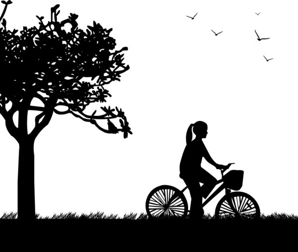 Молодая женщина на велосипеде в парке в весеннем силуэте
