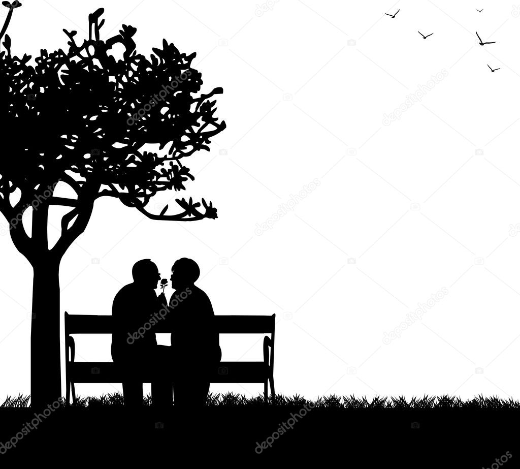 Lovely retired elderly couple sitting on bench in park with flower