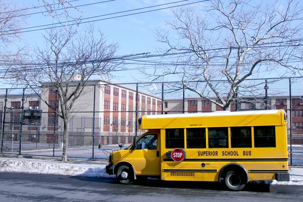 School bus in front of public school — Stock Photo, Image