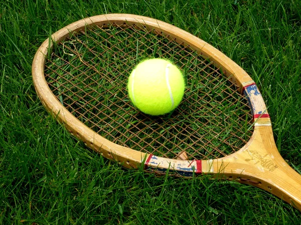 Vintage tennis racket with ball on grass court — Stock Photo, Image