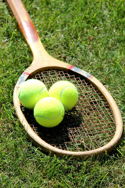 Raqueta de tenis vintage con pelotas en la cancha de hierba — Foto de Stock