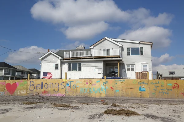 Señales frente a casa de playa dañada en área devastada cuatro meses después del huracán Sandy el 28 de febrero de 2013 en Far Rockaway, NY — Foto de Stock