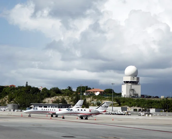 Private jets and traffic control tower in Princess Juliana Airport , St. Maarten