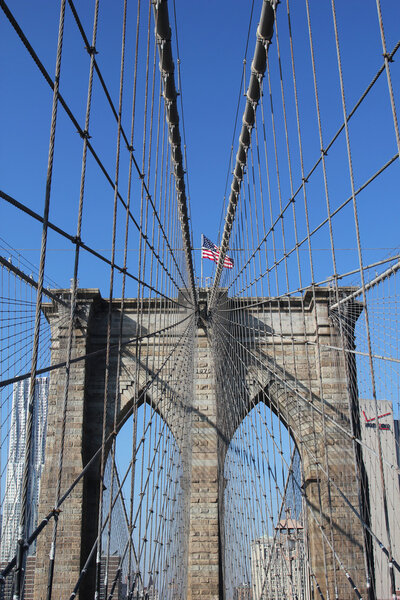 American flag on top of famous Brooklyn Bridge