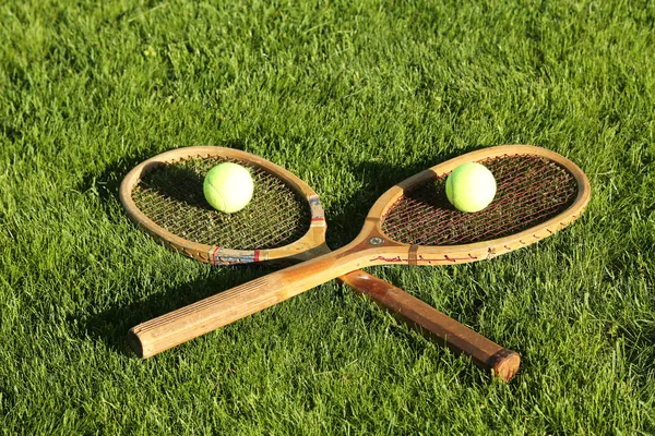 Old tennis rackets on grass court — Stock Photo, Image