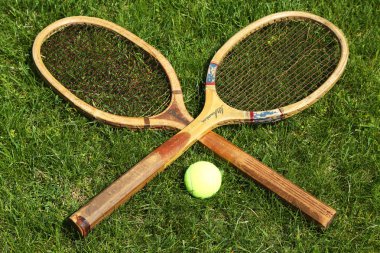 Old tennis rackets on grass court clipart