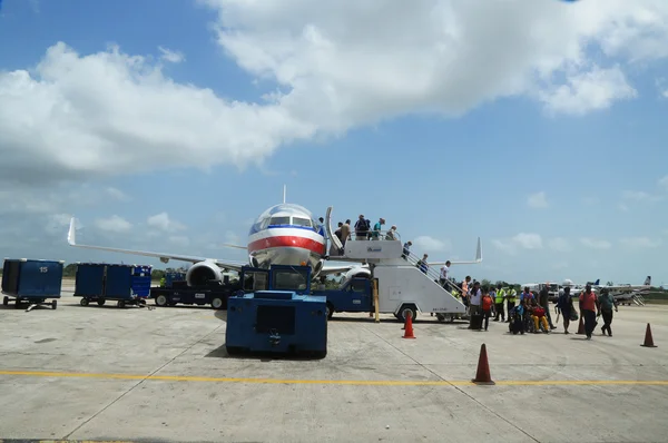 Passagiers uitstappen van Amerikaanse luchtvaartmaatschappijen vliegtuig landde op de luchthaven van philip goldson in belize — Stockfoto