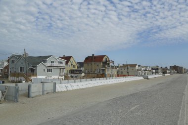 Protective barrier build to prevent damage in devastated residential area one year after Hurricane Sandy clipart