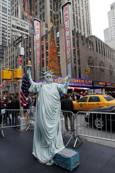 Neidentifikovaný pouliční umělec představuje jako Socha svobody v new Yorku mezník radio city music hall v Rockefellerově centru přední — Stock fotografie