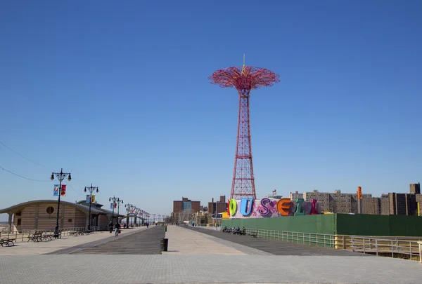 Coney island promenade met parachute springen op de achtergrond — Stockfoto