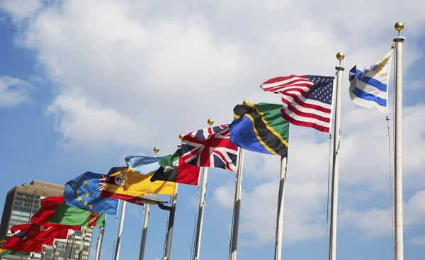 Internationale vlaggen in de voorkant van Verenigde Naties hoofdkantoor in new york — Stockfoto