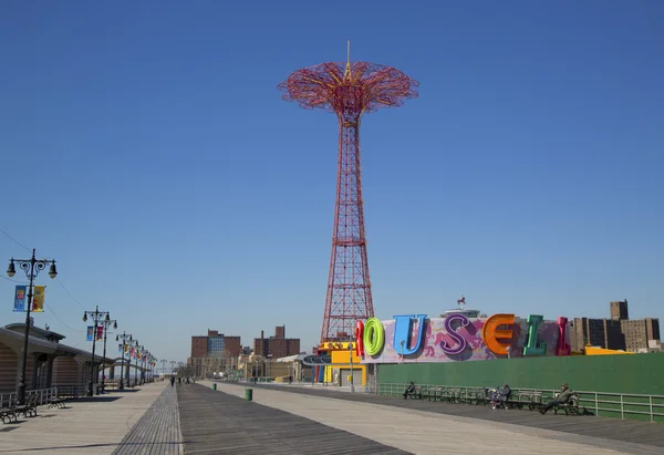 Coney island promenade met parachute springen op de achtergrond — Stockfoto