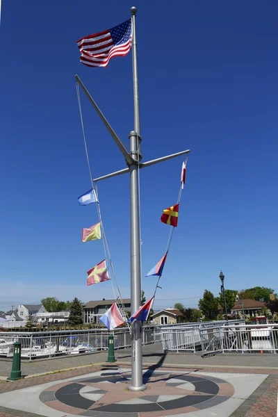 American flag and nautical flags flying at Woodcleft Esplanade in Freeport, Long Island — Stock Photo, Image