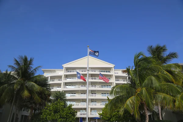 Cayman Islands, United States and State of Texas flags in the front of luxury resort located on the Seven Miles Beach at Grand Cayman — Stock Photo, Image