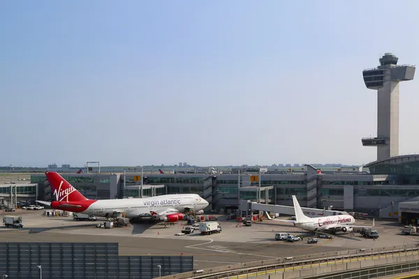 Letecké dopravní řídící věž a terminálu 4 s virgin atlantic boeing 747 a caribbean airlines boeing 737 před branami na letišti jfk v New Yorku — Stock fotografie