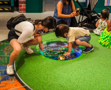 NEW YORK CITY - 22 Temmuz 2021: Çocuklar ve aileler Manhattan 'da Beşinci Cadde' de yeni açılan LEGO bayrak gemisi mağazasında iyi eğlenceler. Lego, dünya çapında çocuklar ve koleksiyoncular arasında popüler bir inşaat oyuncağı serisidir. 