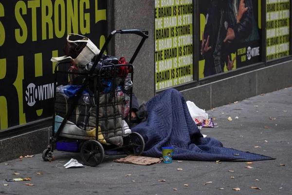 NEW YORK - 28 Kasım 2021: Manhattan 'ın merkezindeki Macy' nin dükkanının yanındaki evsiz adam