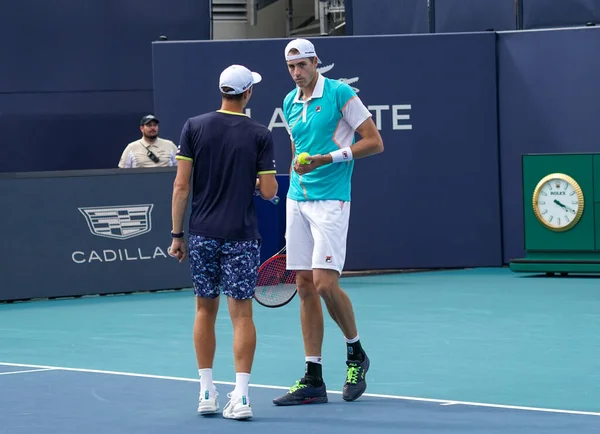 MIAMI GARDENS, FLORIDA - 30 Mart 2022: ABD 'li tenis oyuncuları John Isner (R) ve Polonyalı Hubert Hurkacz, Miami' deki Hard Rock Stadyumu 'nda oynanan 2022 Miami Açık çeyrek final maçında