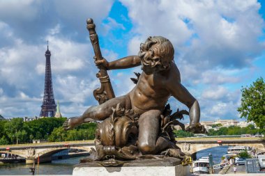 Paris, Fransa 'da güzel bir yaz günü Eyfel Kulesi' nin arka planında, Pont Alexandre III 'te aşk tanrısı heykeli.