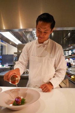 NEW YORK - AUGUST 20, 2022: Chef de Cuisine Joe Rhee plating at Two Michelin Stars Jean-Georges restaurant by French chef Jean-Georges Vongerichten in Manhattan