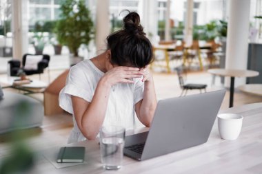 Bunalımlı, uzaktan kumandalı, üzgün bir kadın bilgisayarın önünde hayal kırıklığına uğramış bir şekilde oturuyor. Ya da çalışma masasının üstünde, pencereleri pencereli, modern, aydınlık oturma odasındaki çalışma masasında.