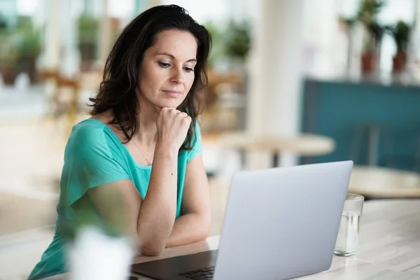 Zamyślony Zamyślony Zdalnie Pracujący Ciemnowłosy Kobieta Siedzi Naprzeciwko Laptopa Lub — Zdjęcie stockowe