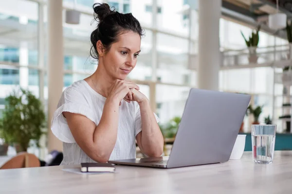 곳에서 일하는 여자가 노트북이나 현대식 공중밝은 사무실의 책상에 — 스톡 사진
