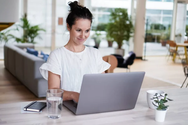 快乐的微笑成功的远程工作的黑头发女人快乐的坐在她的现代阁楼客厅客厅的办公桌上 坐在笔记本电脑或笔记本电脑前 与人视频聊天 — 图库照片