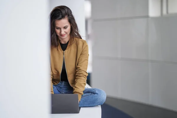 Szczęśliwy Piękny Student Kobieta Pracuje Zdalnie Naprzeciwko Notebooka Casual Dżinsy — Zdjęcie stockowe