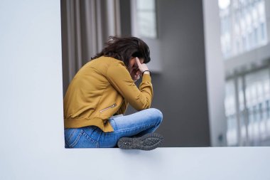 Modern beyaz iç mekan duvarlarıyla çevrili motivasyon için kamerayı işaret eden mutlu bir iş kadını.