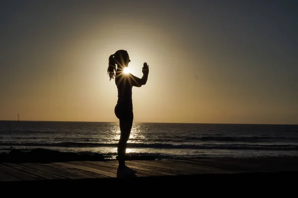 Silhuett Sportig Kvinna Namaste Pose Utövar Yoga Meditation Strandpromenaden Solnedgången — Stockfoto