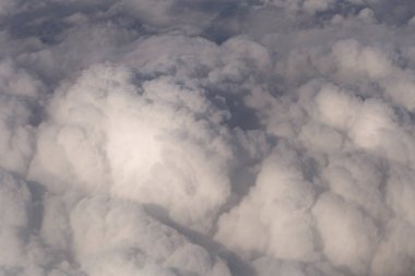 Stratosfer, bir uçak penceresinden bulutların görüntüsü. Gökyüzünde kümüliform bulutları. Arazinin üzerinde uçarken.
