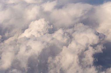 Stratosfer, bir uçak penceresinden bulutların görüntüsü. Gökyüzünde kümüliform bulutları. Arazinin üzerinde uçarken.