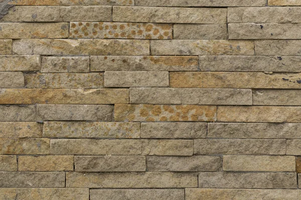 錆のスポットと狭い砂岩タイルの装飾的なベージュエンボスクラッディングと壁 外壁としての石工の例 — ストック写真