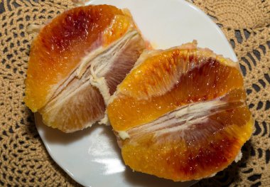 Soyulmuş ve dilimlenmiş portakallı bir tabak. Taze kanlı meyve..