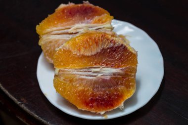 Soyulmuş ve dilimlenmiş portakallı bir tabak. Taze kanlı meyve..