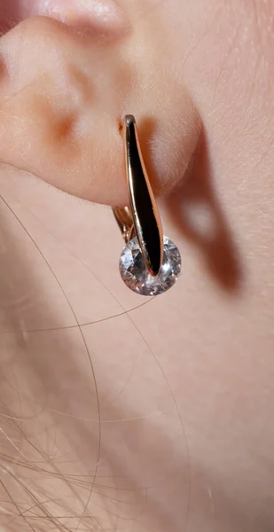 An earring on a woman\'s ear. Ladies\' jewelry.