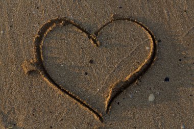 A heart drawn in the sand. Art open air.
