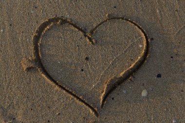 A heart drawn in the sand. Art open air.